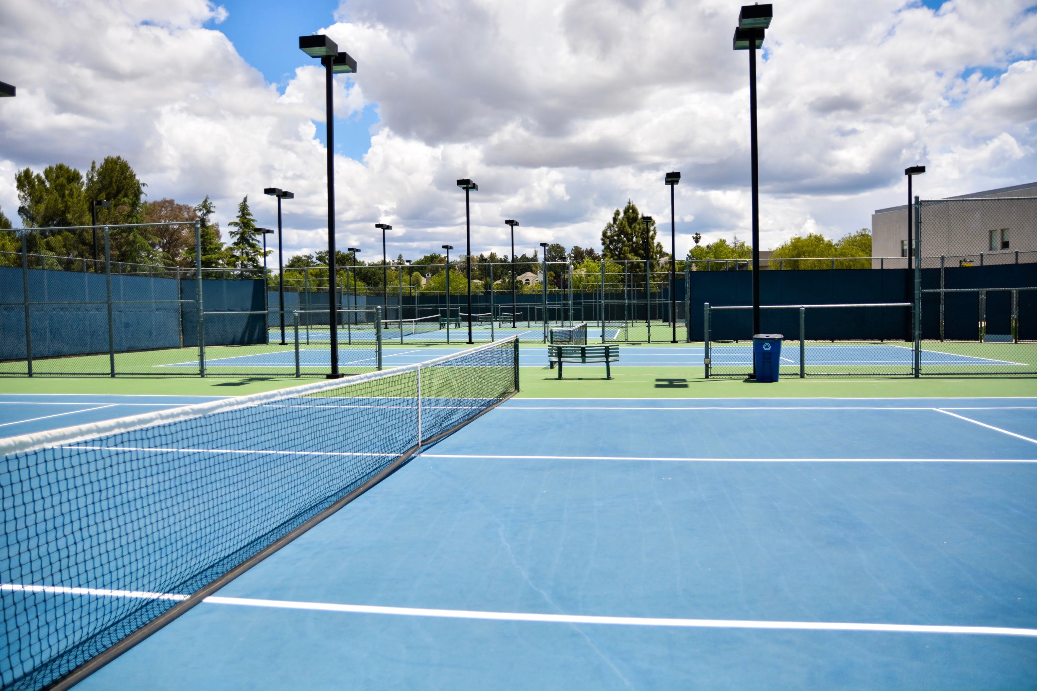 College of the Canyons Cougar Courts outdoor tennis facility at the Valencia Campus featuring multiple lighted courts and blue playing surfaces.